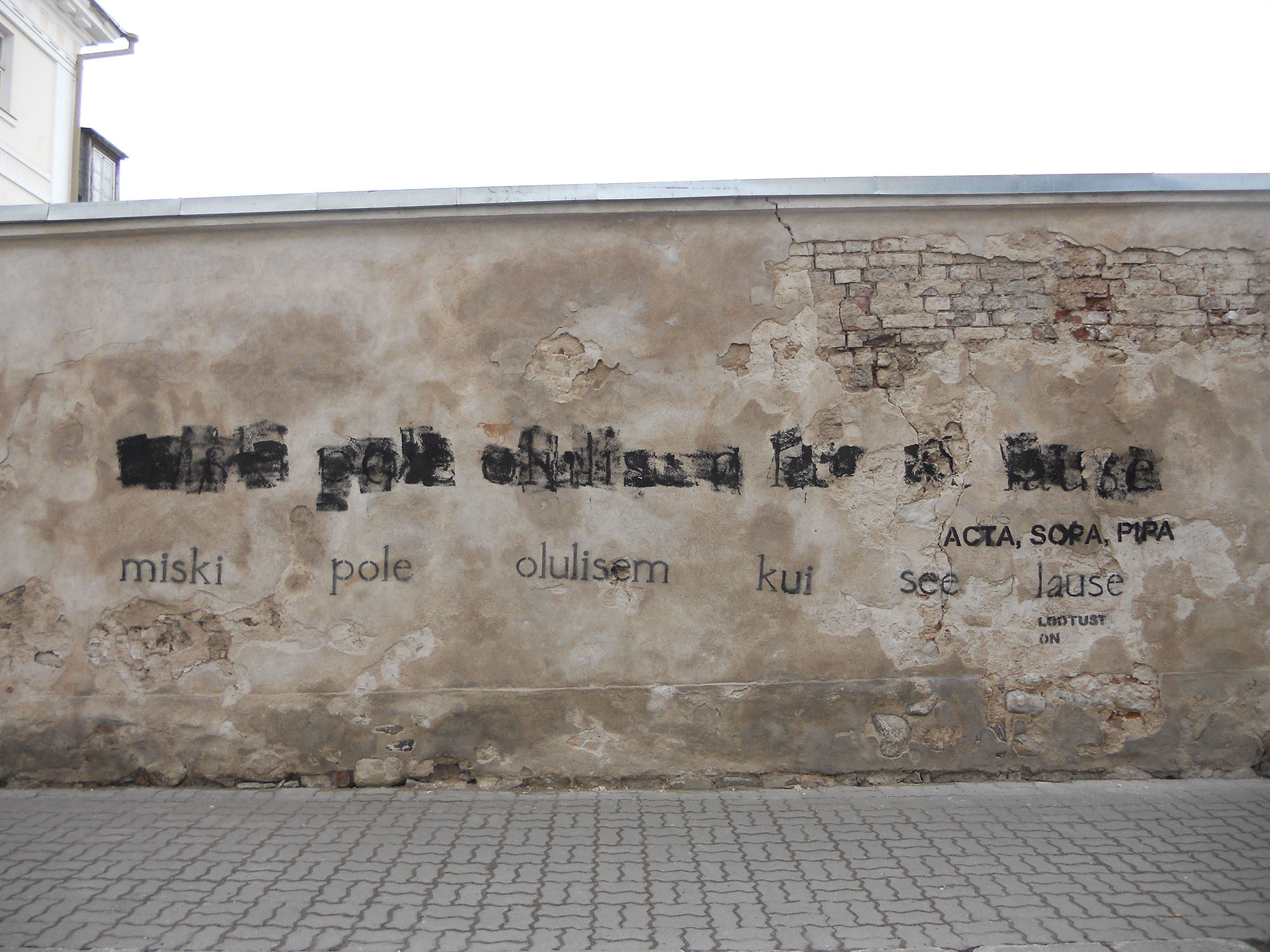 Grafiti hallil seinal musta värvi tekstiga "Miski pole olulisem kui see lause".