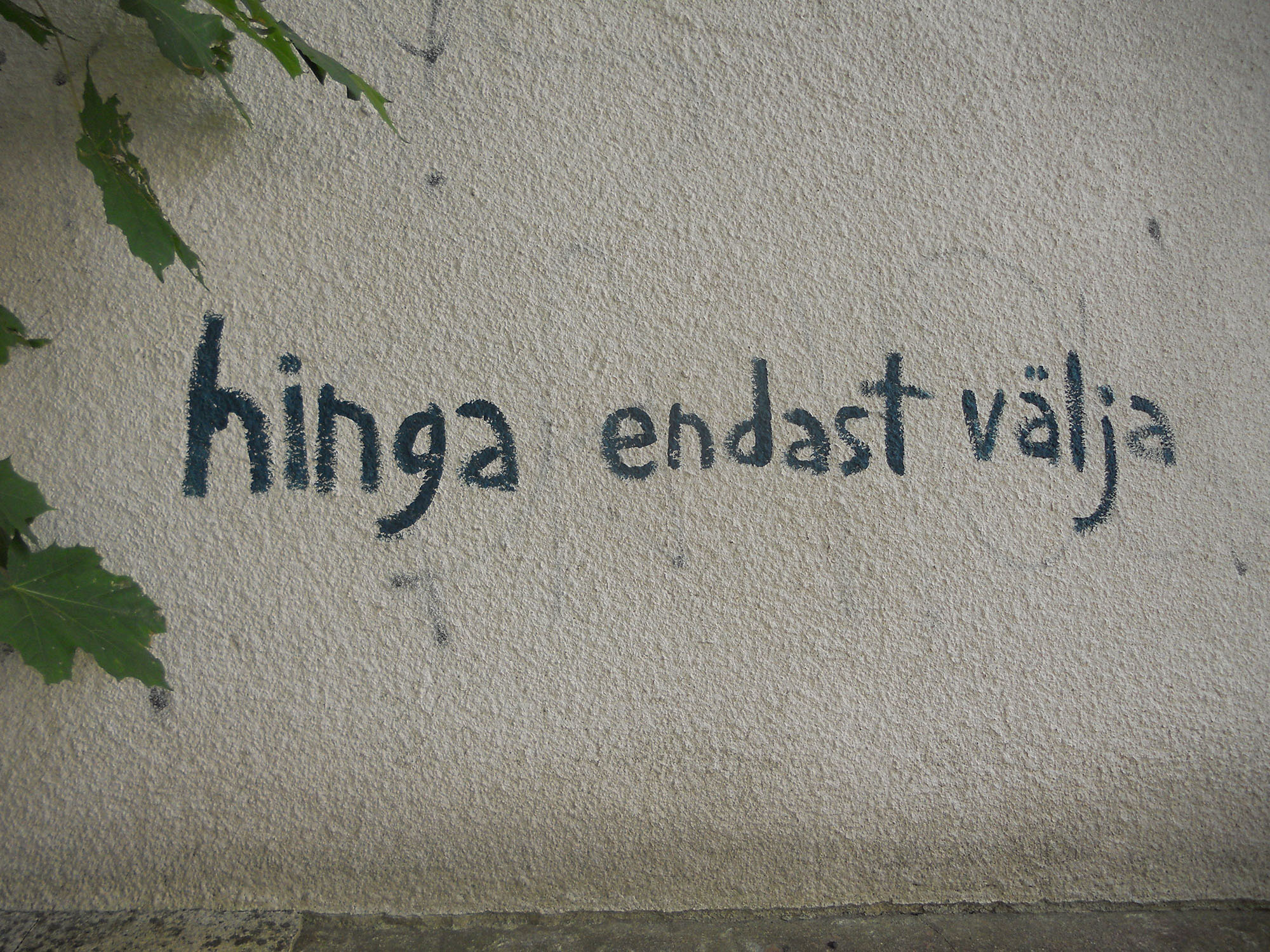Graffiti valgel seinal tekstiga "Hinga endast välja".