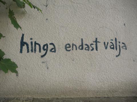 Graffiti valgel seinal tekstiga "Hinga endast välja".